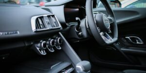 Explore the sleek interior of a modern luxury Audi, featuring a detailed view of the steering wheel and dashboard.